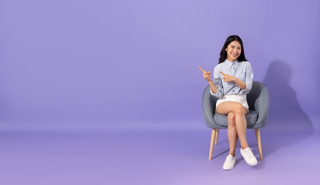 Image of girl sitting on sofa isolated on purple background