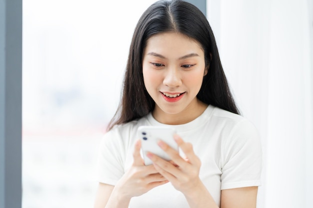 Image of girl using phone next to window