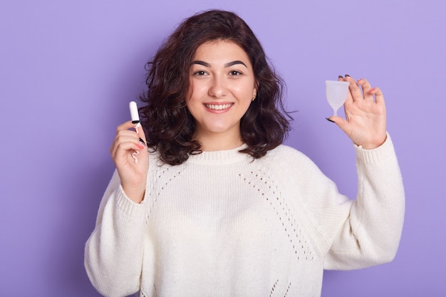 Immagine di bella ragazza piacevole che sta isolata sopra il lillà