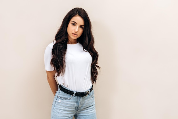 Photo image of gorgeous young woman posing isolated over white wall background brunette girl looking at the camera attentively