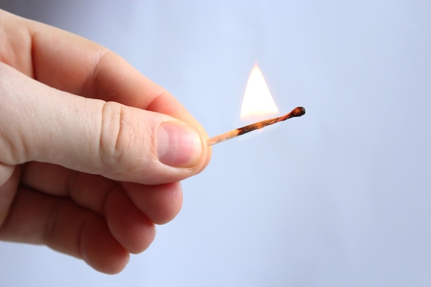 The image of hand with blazing match