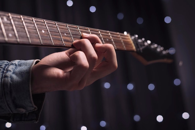 Image of the hands of a musician playing the electric guitar.\
the concept of concerts and entertainment events. mixed media