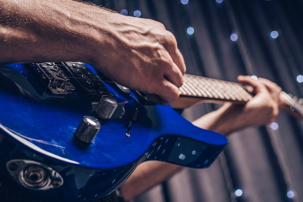 Image of the hands of a musician playing the electric guitar.\
the concept of concerts and entertainment events. mixed media