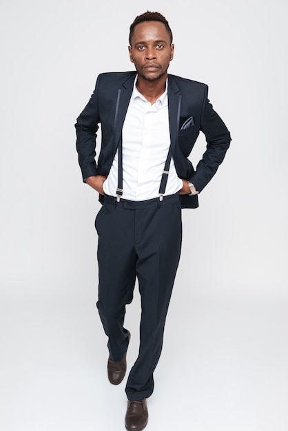 Image of handsome young african businessman posing in studio. Isolated over white background. Look at camera.