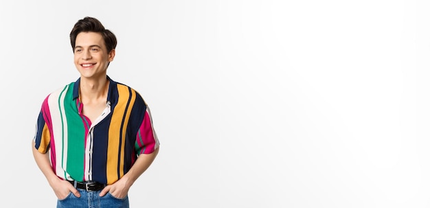 Image of handsome young man in colored summer shirt looking happy standing over white background