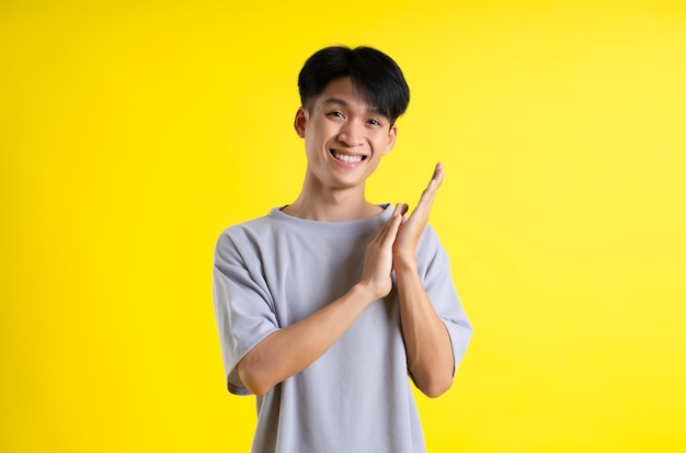 Image of handsome young man posing on a yellow background