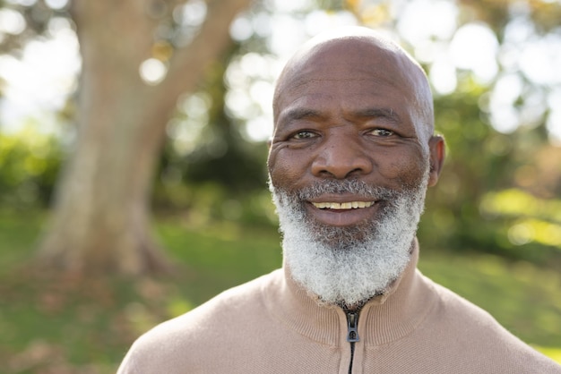 Photo image of happy african american man smiling at camera in garden