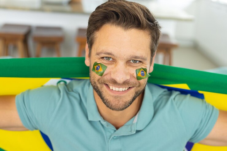 Photo 顔にブラジルの国旗を掲げた幸せな白人男性の画像