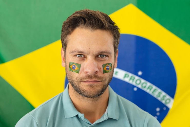 Photo 顔にブラジルの国旗を掲げた幸せな白人男性の画像