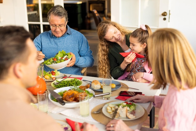 Foto immagine di una felice famiglia caucasica allargata che cena insieme. famiglia e trascorrere del tempo di qualità insieme concetto.