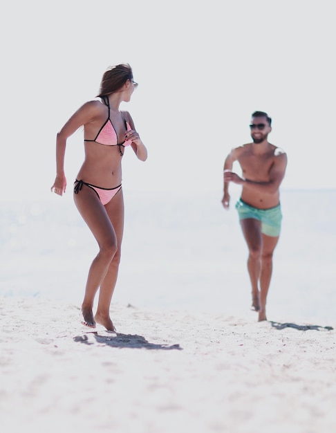 Image of happy lovers running on the beach