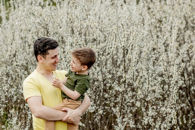 Image of happy man holding his son while having fun