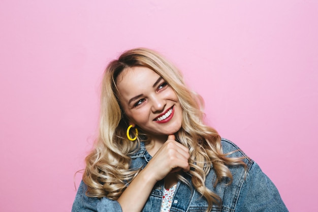 Image of a happy young blonde girl posing fashion and gestures over pink wall