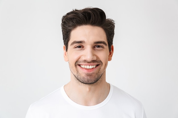 Image of a happy young excited emotional man posing isolated over white wall .