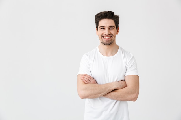 Image of a happy young excited emotional man posing isolated over white wall .