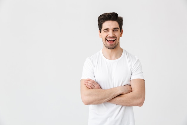 Image of a happy young excited emotional man posing isolated over white wall .