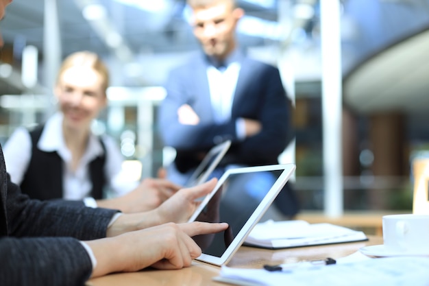 Image of human hand pointing at touchscreen in working environment at meeting.