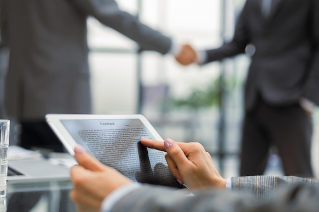 Image of human hands during discussion of paper and electronic documents at meeting