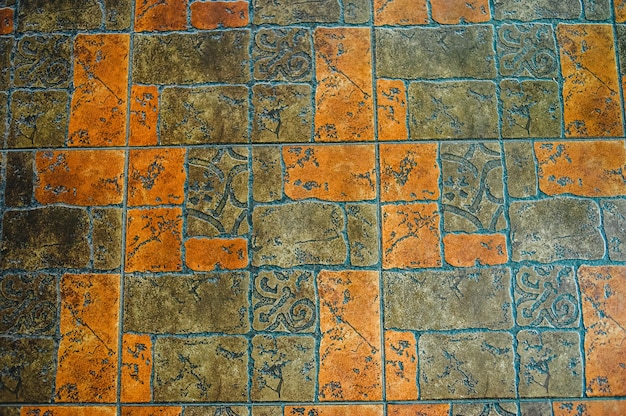 Image of interior flooring with red orange pavement slabs. The texture of the tile is red and gray