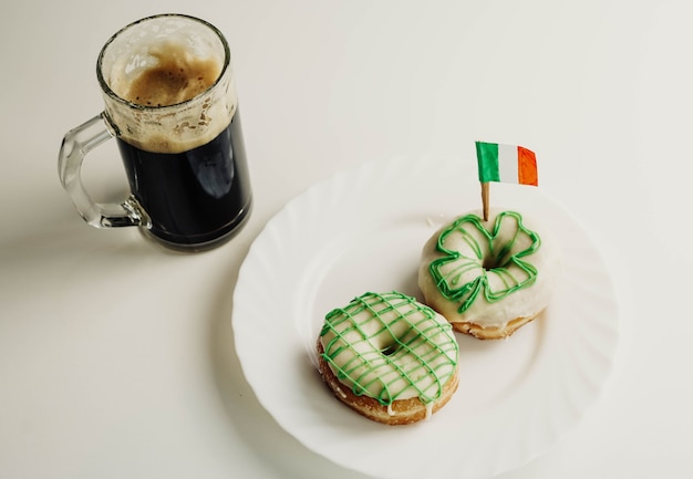 Image of an Irish breakfast to celebrate Saint Patrick consisting of two homemade donuts and a beer