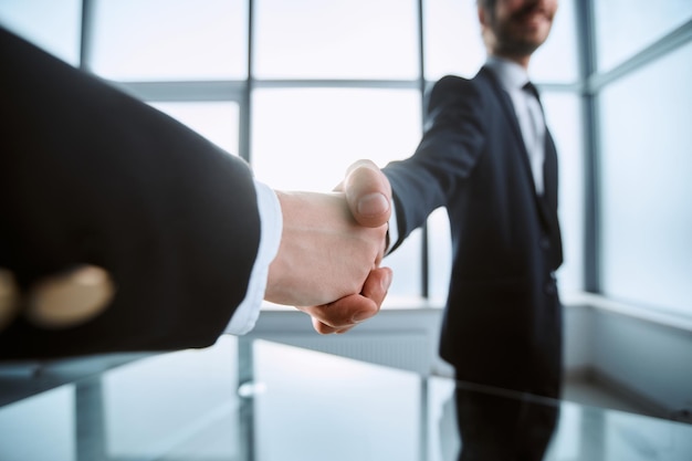 Image is a confident handshake of business partners