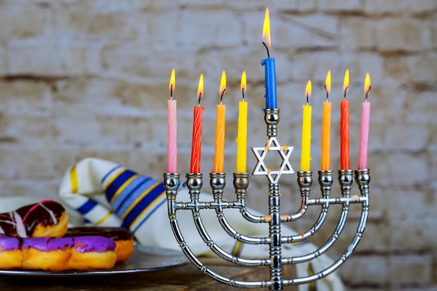 Image of jewish holiday Hanukkah with menorah traditional Candelabra , donuts