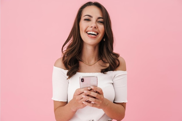 Image of Joyful Brunette Woman Using Cellphone and Laughing