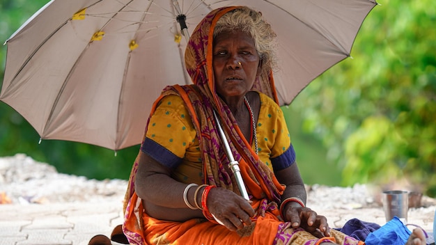 Image of a lady beggar sitting aside of road