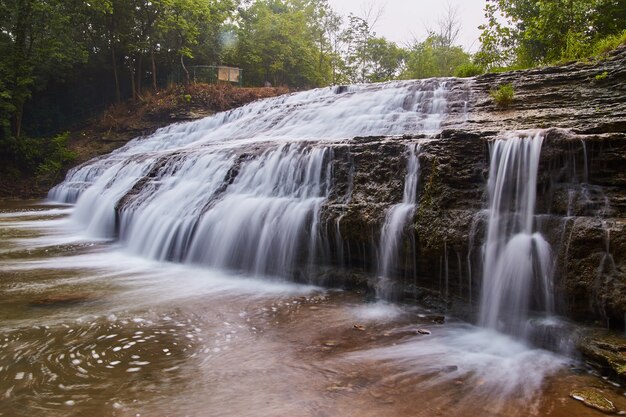 Image of Large cascading waterfall over slates and cliffs of rock