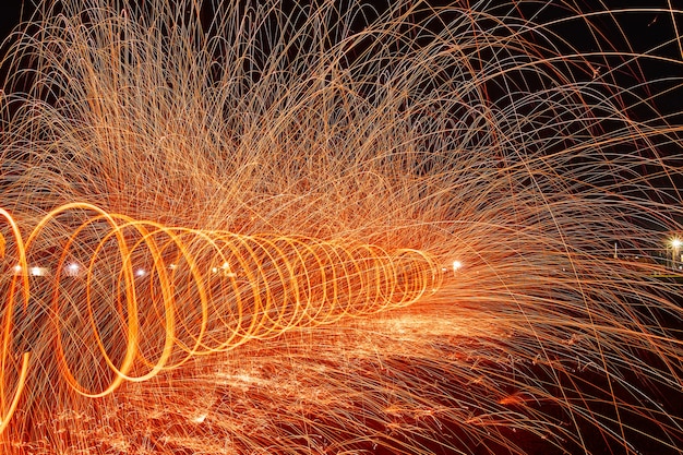 Image of Magical twisting rings of orange sparks at night