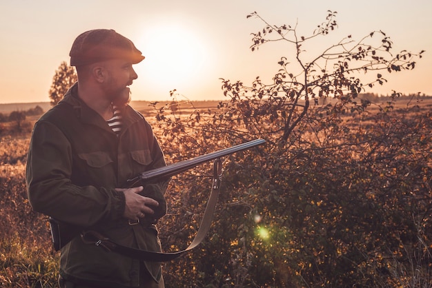 Image of a man with a shotgun while hunting. Duck hunting season. Mixed media