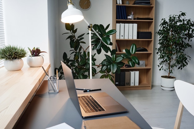 Image of modern workplace of business person with laptop on it at office