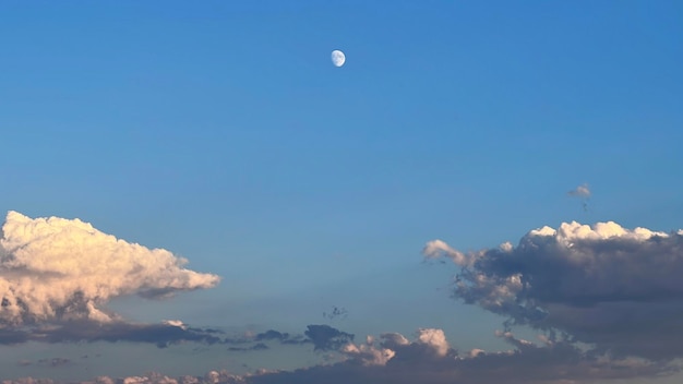 Изображение луны в голубом небе с облаками во время захода солнца Изображение для фона