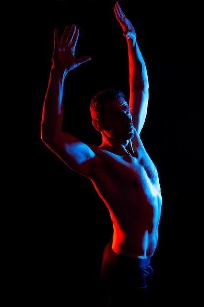 Foto immagine di un uomo muscolare che posa in studio sullo sfondo bianco-rosso scuro