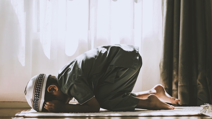 Photo image of muslim preschool kid prays to god doing  dua or supplication concept of muslim kid praying