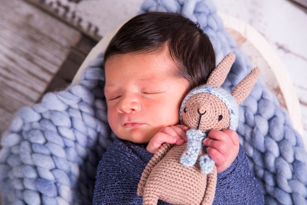 image of a newborn brazilian baby curled sleeping in a blanket