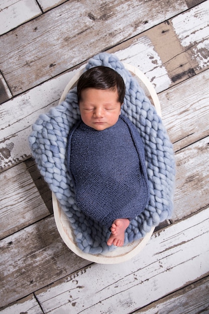 image of a newborn brazilian baby curled sleeping in a blanket