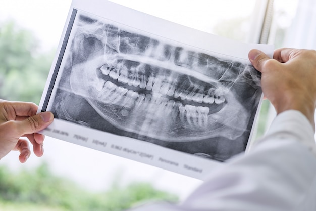 Фото Изображение доктора или стоматолога холдинг и глядя на рентген