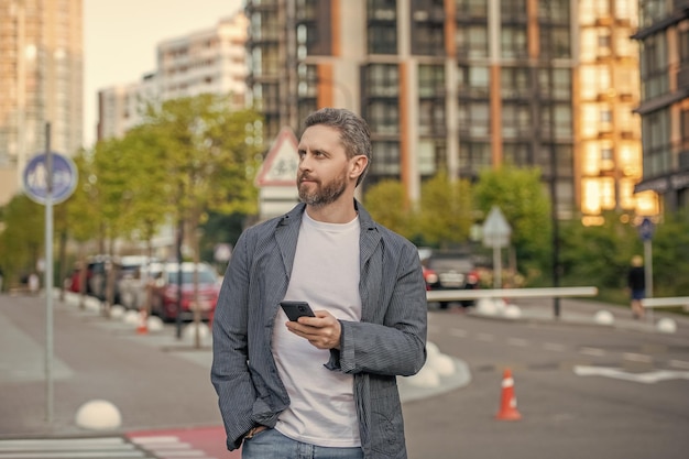 写真 手に携帯電話でチャットする男の画像 外でチャットする男の画像