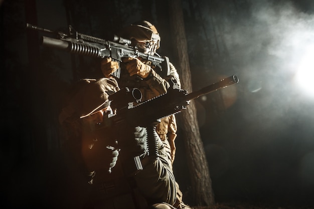사진 전투 작전에서 움직이는 연기 속 군인의 이미지. 역광, 어두운 밤, 숲