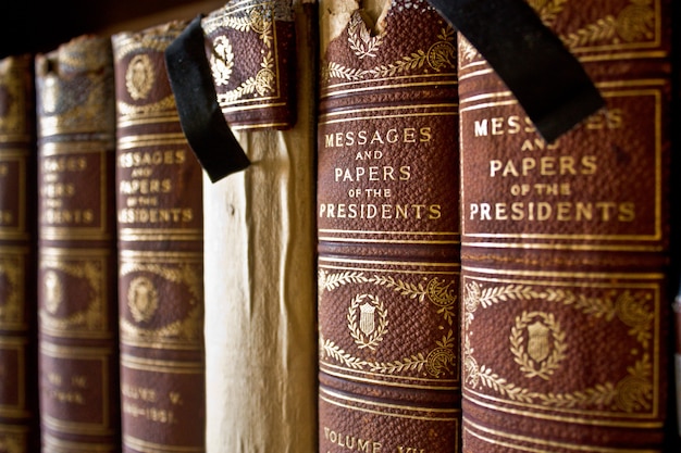 Image of Old books bound with cloth lined up on a shelf