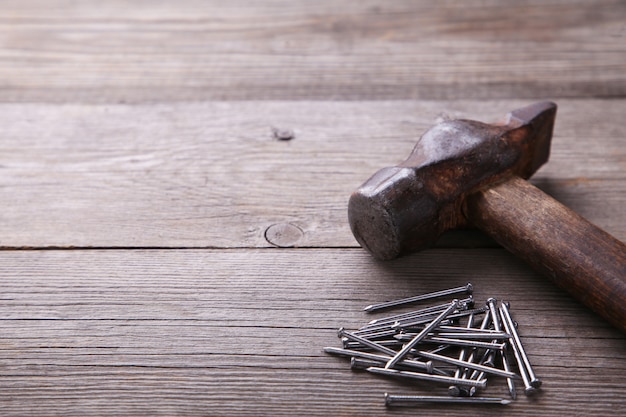 An image of old hammer and nails on grey background table