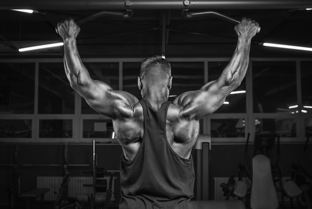 Immagine di un potente atleta che fa un pull-up in palestra. ritorno di pompaggio. concetto di fitness e bodybuilding. tecnica mista