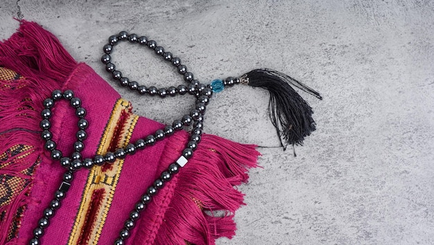 Image of a Praying beads on a sajadah Carpet for moslem praying