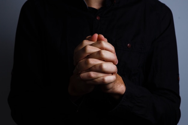 Image of praying hands on a black background