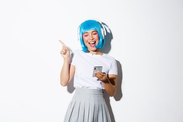 Изображение довольно азиатской девушки в синем парике, слушающей музыку в наушниках