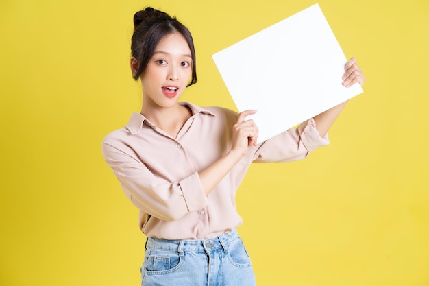 Image of a pretty asian girl holding a white billboard