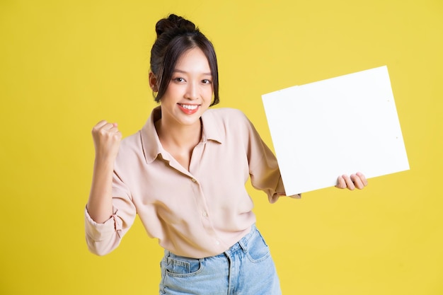 Image of a pretty asian girl holding a white billboard