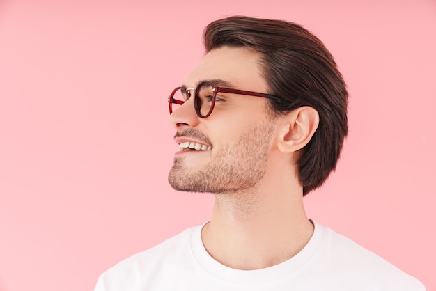 Image in profile of funny caucasian man wearing eyeglasses smiling and looking forward isolated