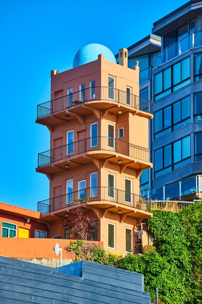 Изображение перил вокруг каждого этажа уникального здания оранжевой башни в Сан-Франциско под ясным голубым небом